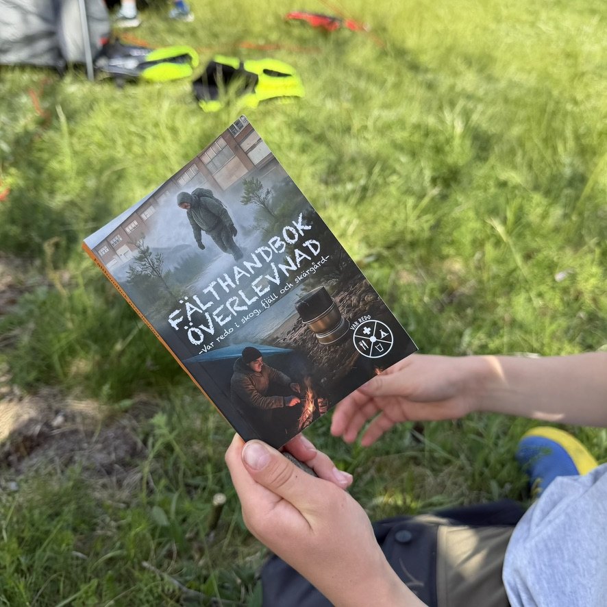 Fälthandbok överlevnad i handen ute i fält